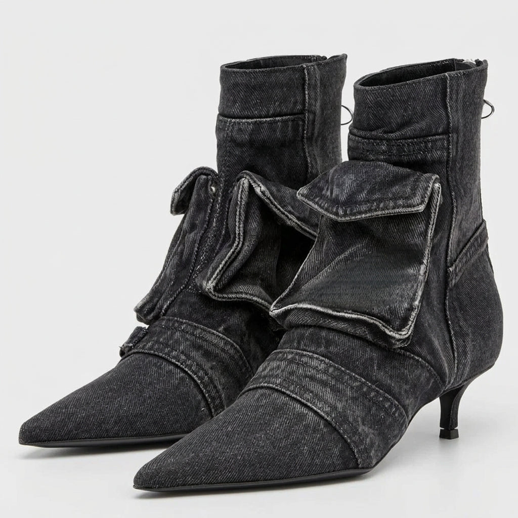 Pair of black denim ankle boots with pointed toes on a white background