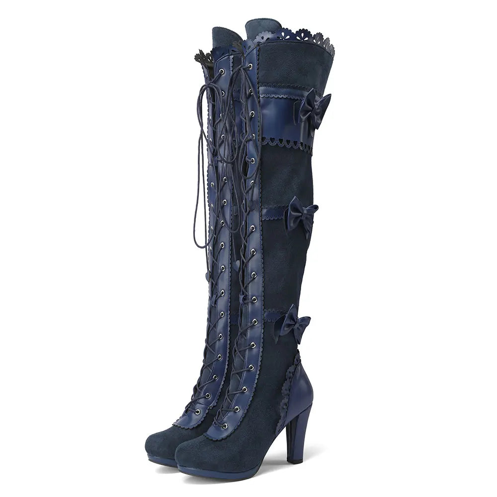 Pair of navy blue knee-high boots with decorative laces on a white background