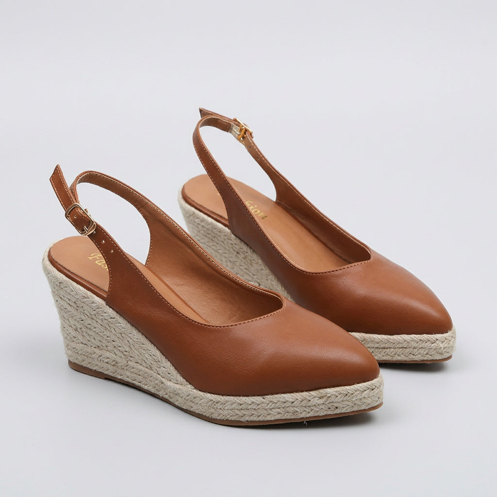 Brown wedge sandals with espadrille sole on a white surface